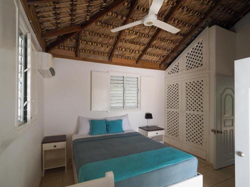 - une chambre avec un lit et un ventilateur de plafond dans l'établissement Bayahibe Guest House Hotel, à Bayahibe