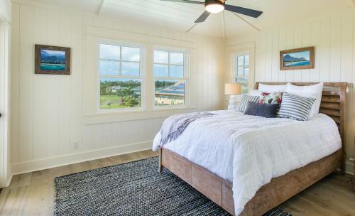 - une chambre avec un lit, un ventilateur de plafond et des fenêtres dans l'établissement Plantation-Style Home with Pool- Alekona Kauai, à Koloa