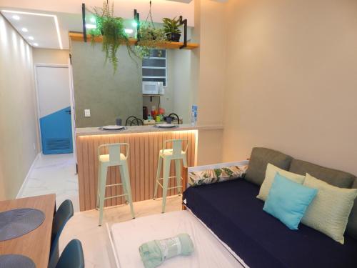 ein Wohnzimmer mit einem Sofa und einer Küche in der Unterkunft Flat Atlântica Alto luxo - Posto 6 Copacabana in Rio de Janeiro