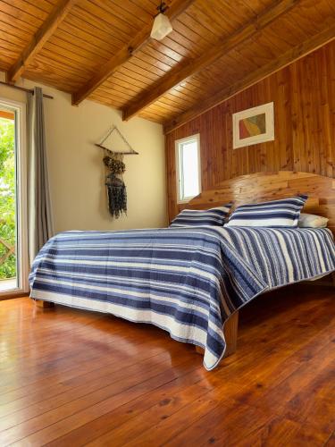 a bedroom with a bed with a blue and white blanket at CABAÑAS Mony in Pucón