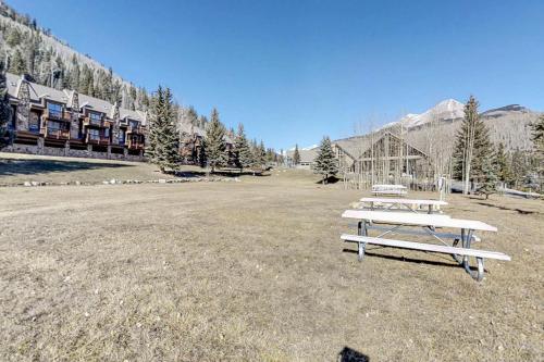 a picnic table in a field in front of a lodge at Cascade 347 in Durango Mountain Resort