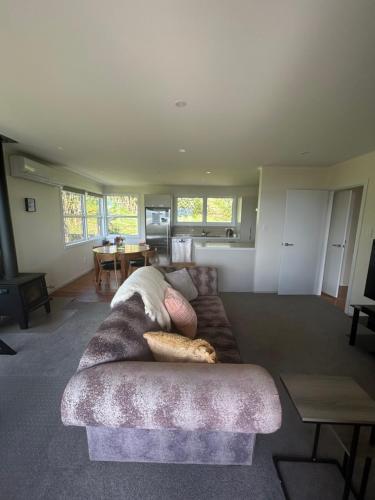 a living room with a couch and a table at Rotorua Lakes Cottage in Rotorua