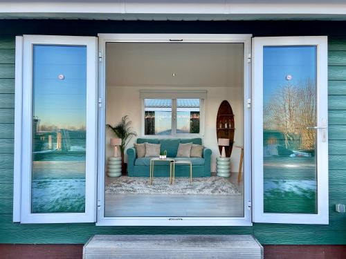 - une vue sur le salon par une porte coulissante en verre dans l'établissement NEW - The Surf Shack - on a lake near Amsterdam!, à Vinkeveen