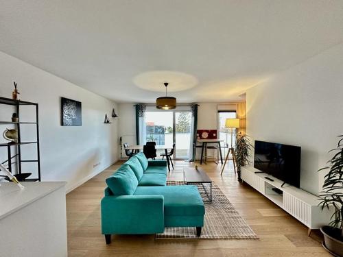 un soggiorno con divano blu e TV di La Frontalière ad Ambilly
