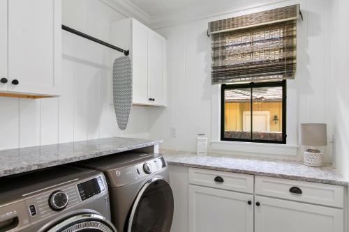 een keuken met een wasmachine en een raam bij Luxury 5 Bed Home with Pool and Spa- Alekona Kauai in Koloa
