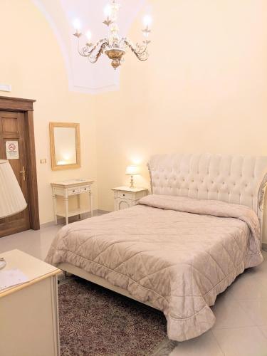 a bedroom with a large bed and a chandelier at Castello Conti Filo in Torre Santa Susanna