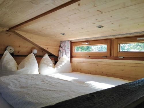 una camera da letto in una baita di tronchi con letto di Tinyhouse Momente Chalet als Rückzugsort für Naturliebhaber im Oberallgäu a Wertach