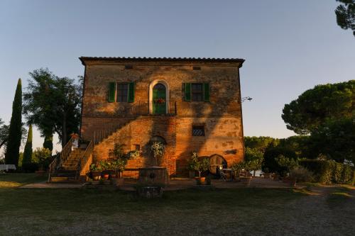 ein großes Backsteingebäude mit grüner Tür und Fenstern in der Unterkunft Villa Cozzano in Pozzuolo