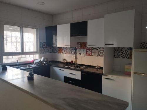 a kitchen with white cabinets and a counter top at Jad tunis in Tunis