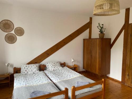 a bedroom with two twin beds and a staircase at Agroturystyka Bobrowniki in Szczytna