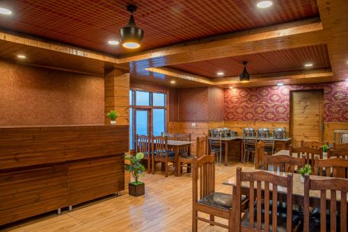 una sala da pranzo con tavoli e sedie in legno di KufriVista Mountain Lodge a Kūfrī