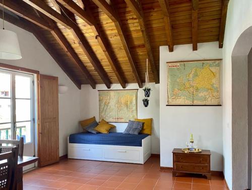 um quarto com uma cama azul e um mapa na parede em The Captain’s House - 2min walking from the beach em Sesimbra