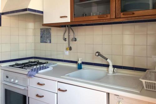 uma cozinha com um lavatório e um fogão em The Captain’s House - 2min walking from the beach em Sesimbra