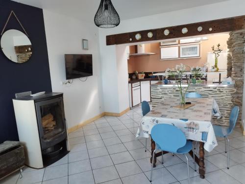 une salle à manger avec une table et une cheminée dans l'établissement A la découverte du cotentin, à Cherbourg en Cotentin