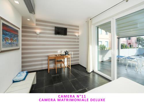 a room with a table and a tv on a striped wall at I Tibei Guesthouse Affittacamere in Monterosso al Mare