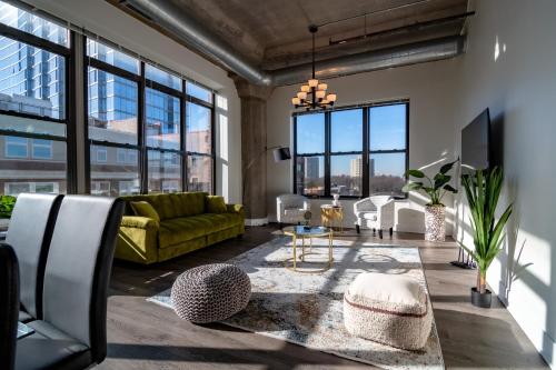 sala de estar con sofá verde y ventanas grandes en Slumber Stay - McCormick en Chicago