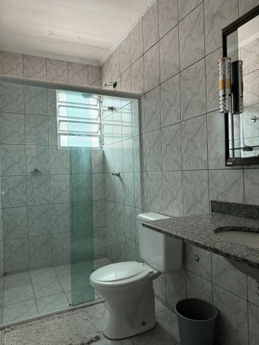 a bathroom with a toilet and a glass shower at Lize Prime Hotel in Campinas
