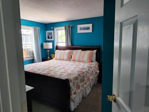 a bedroom with a bed with blue walls at Summer Sea Vacation Rental in South Yarmouth
