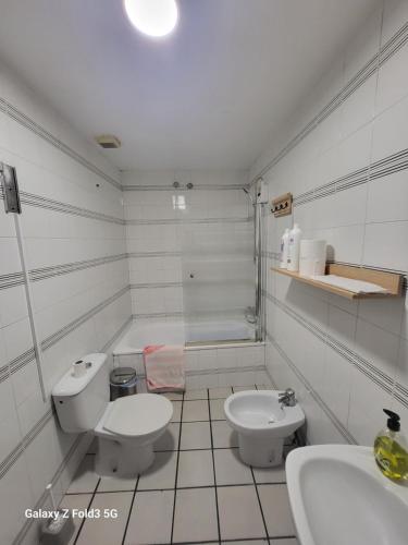 bagno bianco con servizi igienici e lavandino di Habitacion muy céntrica. a Granada