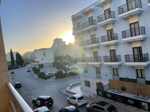 vista su una strada con auto parcheggiate di fronte a un edificio di SunnyGem Retreat a San Pawl il-Baħar