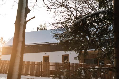 a white building with a snow covered roof at Aparthouse Lubno in Frýdlant nad Ostravicí