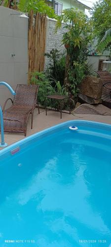 a swimming pool with two chairs and a bench at Canto da Natureza in Governador Celso Ramos