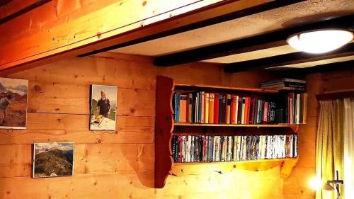 uma parede com duas estantes cheias de livros em Apartment Nr 4, Chalet "ARVE" em Riederalp