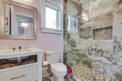 a bathroom with a shower and a toilet and a sink at Sprawling Suwanee Home Theater, Pool, Hot Tub! in Suwanee