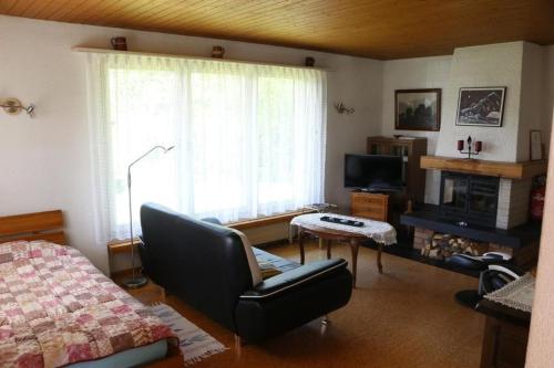 a living room with a bed and a chair and a window at Akalei - b48493 in Aeschi