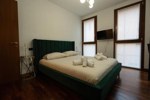 a bedroom with a large bed with two stuffed animals on it at Appartamento Il Crocevia in Piacenza