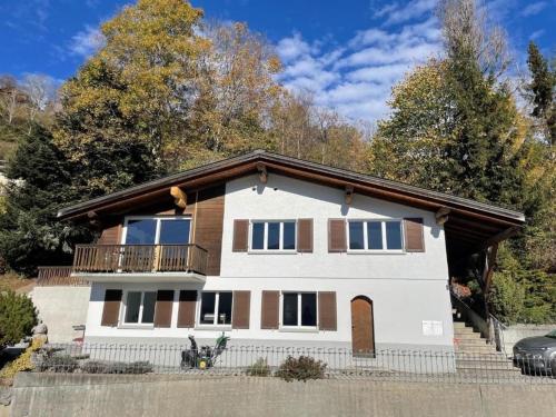 a white house with a balcony on top of it at Casa Campanula - No 1 Ferienhaus in Laax in Laax