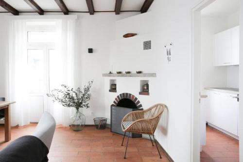 ein Wohnzimmer mit weißen Wänden und einem Kamin in der Unterkunft Casa Lucertola - Freistehendes Tessinerhaus weit oberhalb des Lago Maggiore mit fantastischer Aussicht in Contra