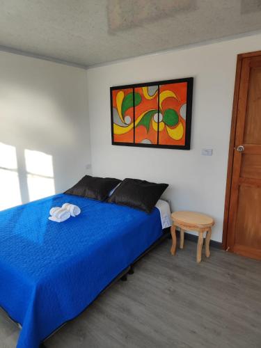 Schlafzimmer mit einem blauen Bett und einem Tisch in der Unterkunft Apartamento vía a termales in Santa Rosa de Cabal