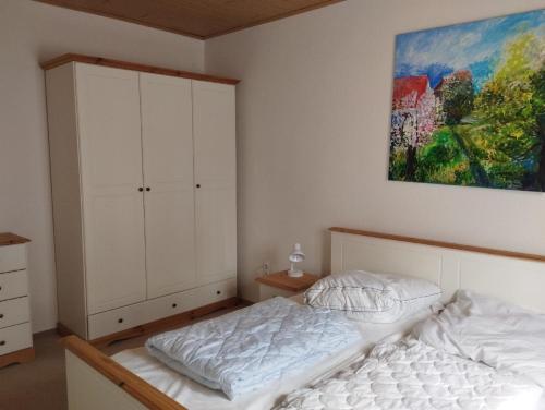 um quarto com uma cama e um quadro na parede em Unterkunft FERIENHAUS TRAUDL & PAUL 