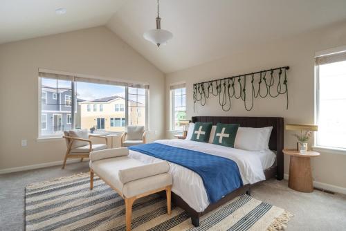 a bedroom with a bed and a chair and windows at Colorado Haven: 5bd - Pool & Foosball - 10min UCB in Superior