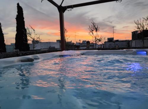 a jacuzzi tub with a sunset in the background at Castello Conti Filo in Torre Santa Susanna