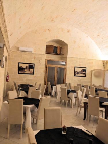 a restaurant with tables and chairs and a brick wall at Castello Conti Filo in Torre Santa Susanna