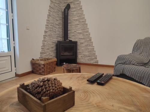 a room with a table with two remote controls and a fireplace at Segredos da Montanha - Seia in Seia