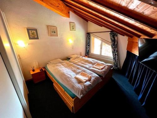 um quarto com uma cama num quarto com uma janela em Villars Soleil em Villars-sur-Ollon