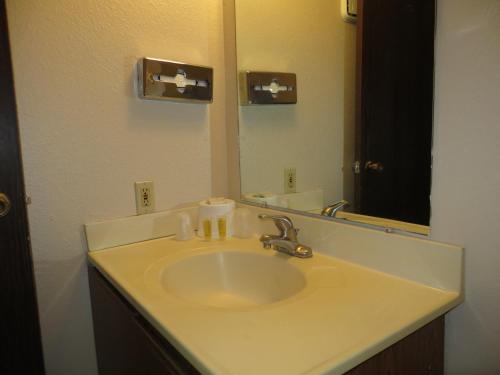 a white sink sitting under a mirror in a bathroom at Longhorn Boulder Highway in Las Vegas