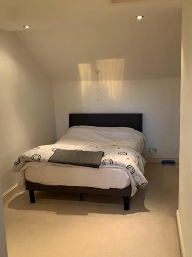 een bed in een witte kamer met bij Holiday Home in Kidderminster in Kidderminster