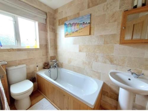 uma casa de banho com uma banheira, um WC e um lavatório. em Holiday Home in Kidderminster em Kidderminster