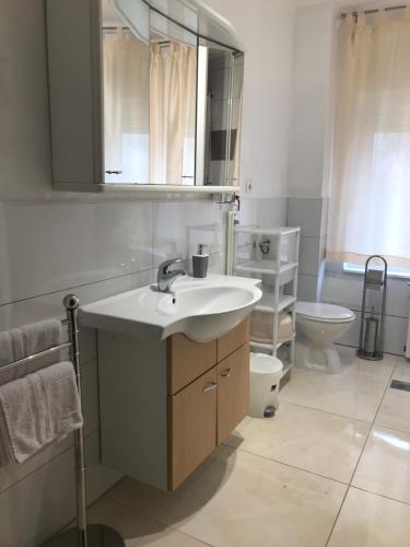 a bathroom with a sink and a toilet at City Retro Chic Apartment Magdalena Trogir in Trogir