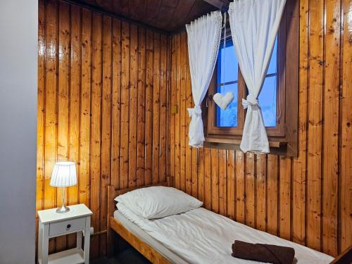 a small bedroom with a bed and a window at SCHRONISKO GOŚCINIEC RÓWNICA in Ustroń
