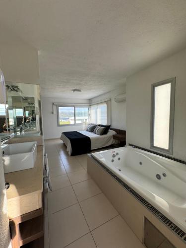 ein Bad mit Badewanne und ein Bett in einem Zimmer in der Unterkunft Casa Calma Puerto del Aguila in Potrero de Garay