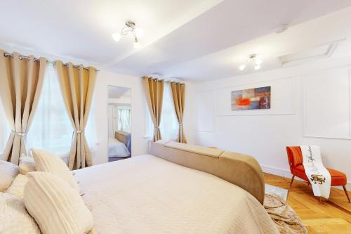 ein weißes Schlafzimmer mit einem Bett und einem Stuhl in der Unterkunft Park Lane Apartments Harrowby street in London