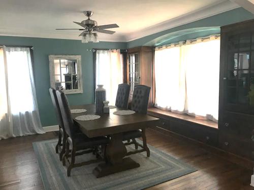 a dining room with a table and chairs and windows at Euclid Beach within reach in Euclid
