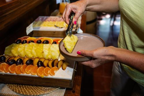 a woman holding a plate of food with oranges at El Tránsito Hotel Boutique in Concepción