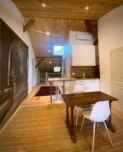 a kitchen with a wooden table and white cabinets at Gîte et Roulotte dans les Vosges in Remiremont