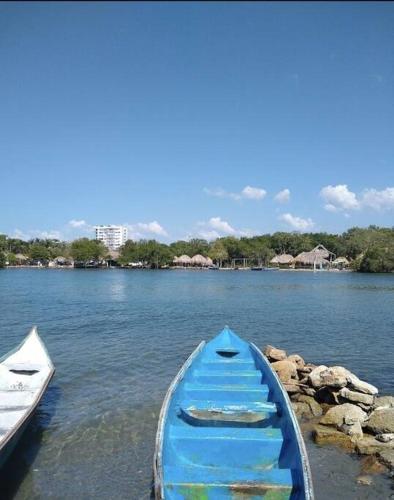 a blue boat sitting on the shore of a lake at SiÉ Cabaña-Finca en Coveñas cerca a la playa in Coveñas